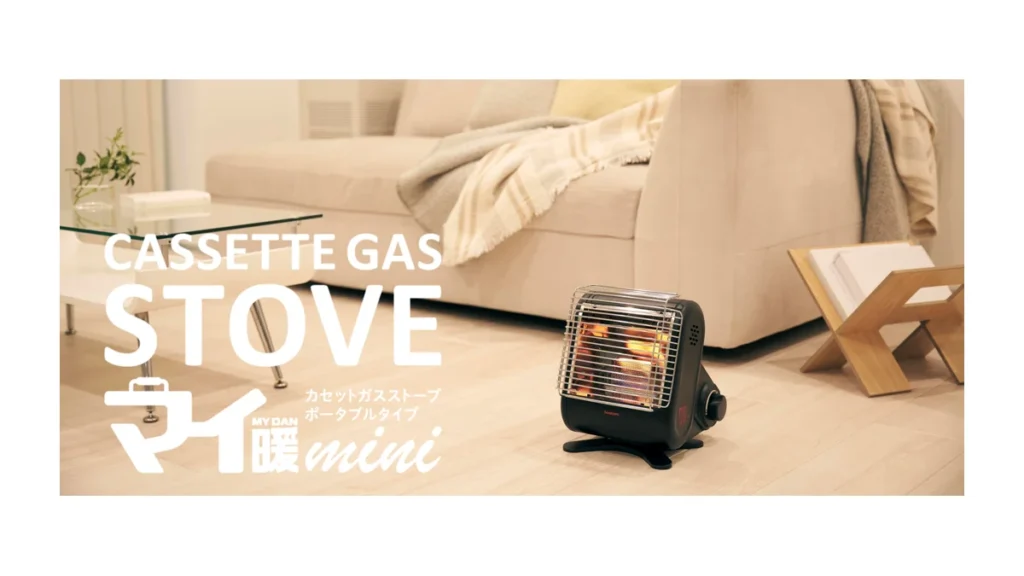 屋内に置かれた黒いイワタニ マイ暖mini（CB-STV-MIN）の公式写真
