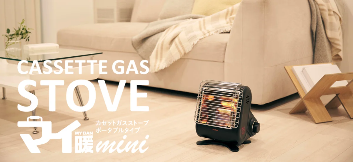 室内に置かれた黒いイワタニ マイ暖mini（CB-STV-MIN）。岩谷産業の公式発表写真